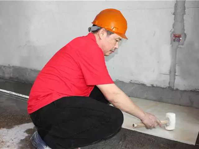 5鋪貼地磚時，磚的背面朝上批刮水泥油，并按箭頭所指方向統一鋪貼，用橡皮錘從中到邊，由重到輕敲實.jpg